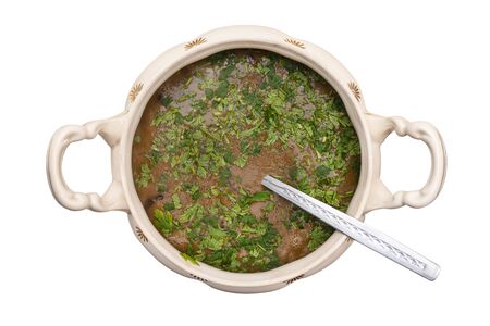 Mushroom soup in a decorative vase with handles, in which there is a ladle, a flat top view, isolated on a white backgroundの写真素材