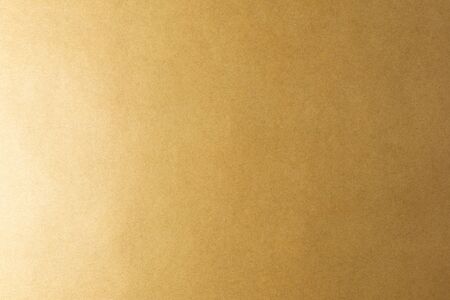 Brown background made of real colored paper, illuminated by a soft light from the left.の写真素材