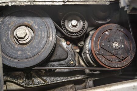 Crankshaft pulley connected by a multi-ribbed belt with tensioner and air conditioning compressor.