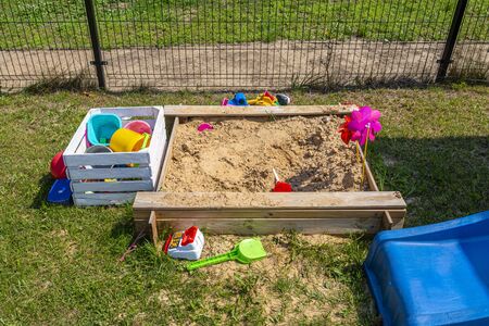Childrens playground by the house garden, visible sandpit, beautiful spring day.の写真素材