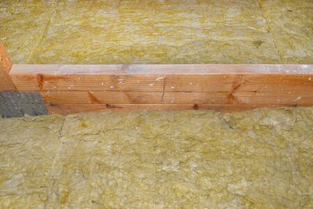 Ceiling and attic floor insulation made of rock wool between the trusses.の写真素材