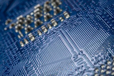 Macro photo of electrical paths on blue circuit board, selective focus.