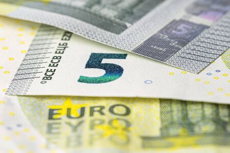 Macro shot of a European Union banknote of 5 EUR, close-up of the number five.