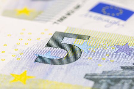 Macro shot of a European Union banknote of 5 EUR, close-up of the number five.