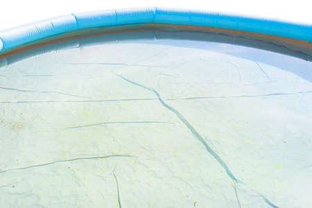 Mildew stains in an unclean domestic pool, dirty and blooming water unsuitable for bathing, isolated on white background.の写真素材