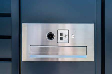 A modern videophone with a letterbox and a wireless card reader, mounted in panel fence in anthracite color.の写真素材