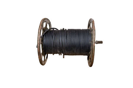 A black electric cable wound on an old metal spool, isolated on a white background  a  .