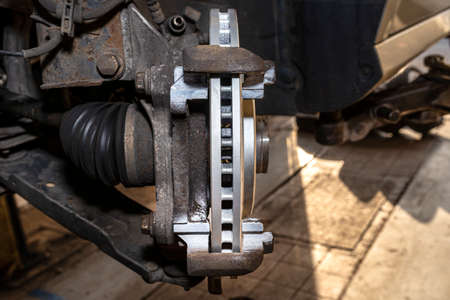 New anti-corrosion coated brake disc mounted on the front hub, a close-up shot of the brake disc...