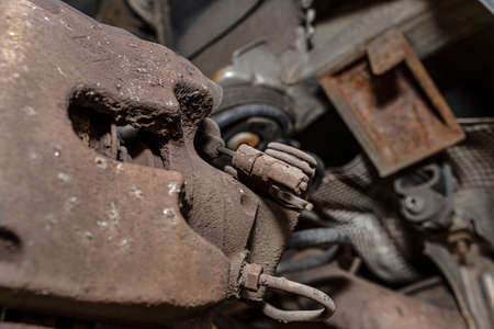 Old brake hose system, mounted to the car, close-up on the handbrake tensioning spring.の写真素材