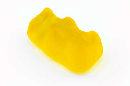 A macro shot of a yellow gummy bear, isolated on a white background.の写真素材