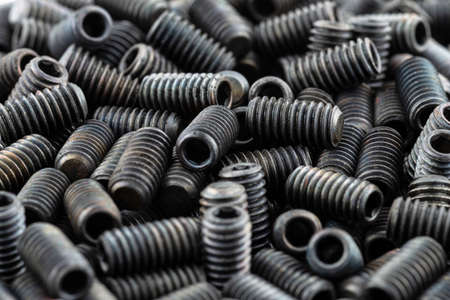 Background made from a macro shot of scattered, black grub screw on table.の写真素材