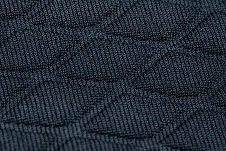 Background made from a macro of real material in dark blue, diamond shapes.