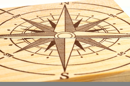 Macro shot of a compass painted on a wooden plank, small depth of field.