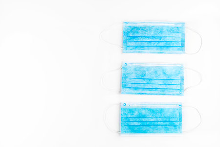 Three blue surgical masks for personal protection against the virus, isolated on a white background, top view.の写真素材