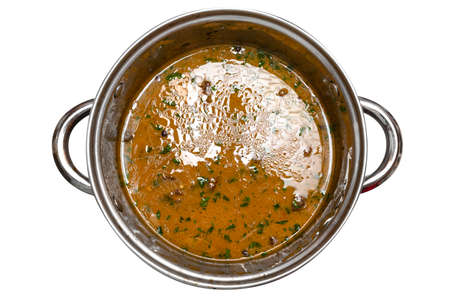 Cooked mushroom soup with celery, leek and parsley in a steel pot, isolated on white background