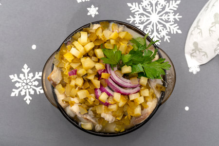 Raw herring in oil with onion, cucumber and parsley, standing in a bowl on the holiday table in Poland.の写真素材