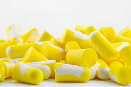 Macro shots of multiple earplugs in yellow and white for noise protection, isolated on white background.の写真素材