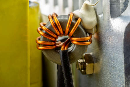 An inductor, toroidal coil on a ring with visible copper scroll, wound on a magnetic coil.の写真素材