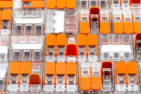 Background made of multiple couplers for strands and solid conductors for electric cables, with a few open levers.の写真素材