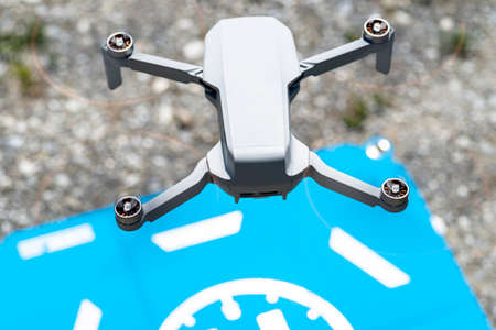 A close-up shot of the drone rotating plastic propellers with brushless motors against the backdrop of a blue landing pad.の写真素材