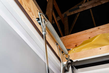 A spring tensioning mechanism that helps in opening a metal ladder to the attic placed in the ceiling of the house.の写真素材