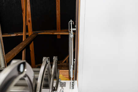 A spring tensioning mechanism that helps in opening a metal ladder to the attic placed in the ceiling of the house.の写真素材