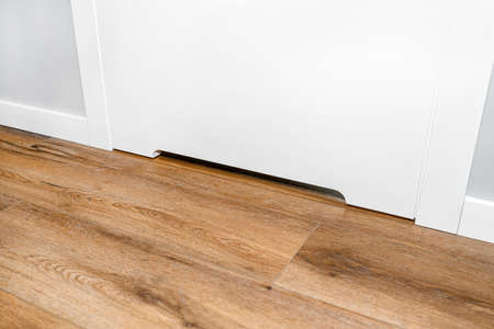 Close up shot of a white door with a vent in a modern home with vinyl planks on the floor.の写真素材