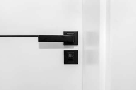 Modern white door with matte black handle and magnetic locks, bathroom door lock.の写真素材