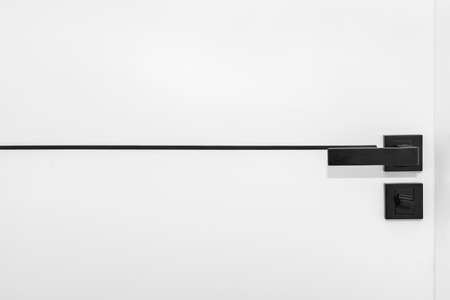 Modern white door with matte black handle and magnetic locks, bathroom door lock.の写真素材