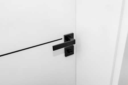 Modern white door with matte black handle and magnetic locks, bathroom door lock.の写真素材