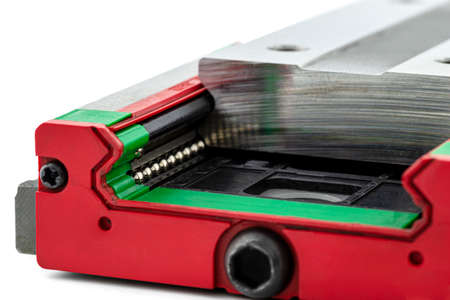 Macro photo of a old linear bearing with a linear trolley, isolated on a white background.