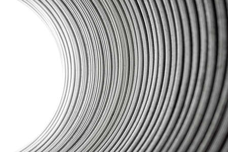 Flexible corrugated aluminum tube seen from the inside, resistant to high temperatures, isolated on a white background, selective focus.の写真素材