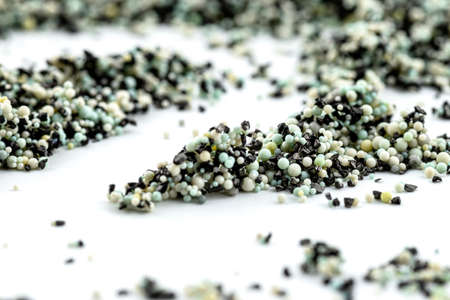 A background made out of strewn inside an activated carbon filter and water filter balls, isolated on a white background, selective focus in the center.の写真素材