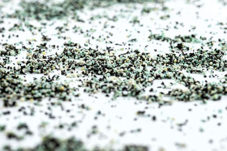 A background made out of strewn inside an activated carbon filter and water filter balls, isolated on a white background, selective focus in the center.の写真素材