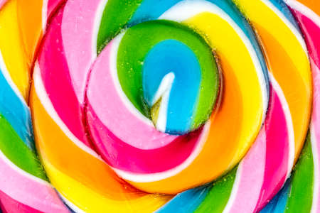A macro photo of a sweet colorful lollipop in the shape of a spiral, top view.の写真素材