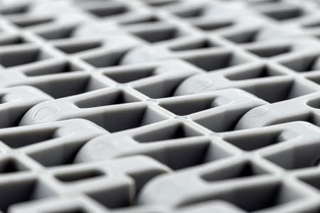 Background made from a macro photo of a plastic conveyor belt combined into sections, selective...