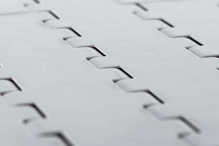 Background made from a macro photo of a plastic conveyor belt combined into sections, selective...