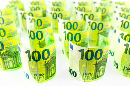 Macro photo of the European Union 100 EURO banknote, banknotes rolled up and standing, isolated on a white background, selective focus.の写真素材