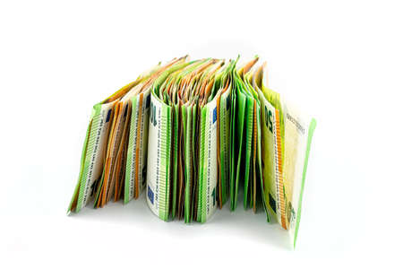 A macro photo of a European Union currency, stacked on a pile of 50 and 100 euro banknotes, isolated on a white background.の写真素材