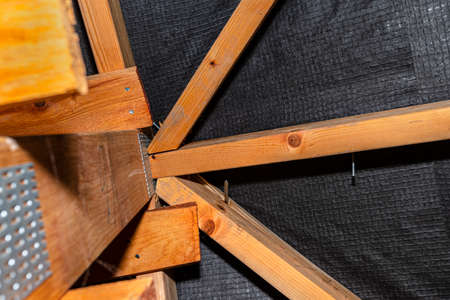 Badly nailed nails connecting the roof truss covered with a membrane on a single-family house,...