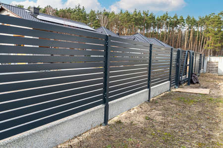 Modern anthracite panel fencing, visible spans and a fence foundation connector, view from the garden.の写真素材
