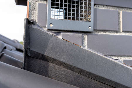 System chimney covered with sheet metal and covered with ceramic tiles, visible grille from gravity...