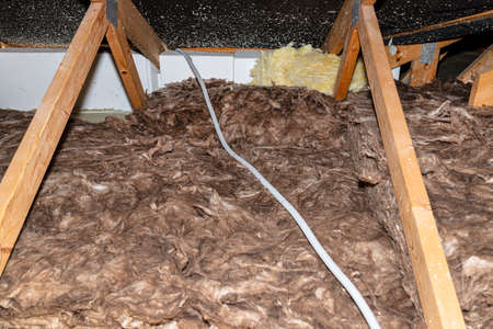 Electric cable in a corrugated conduit on the roof trusses, located in the attic of the house.