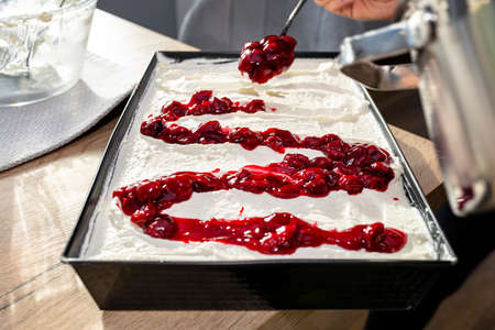 Pour the cherry sauce over the cheesecake with a teaspoon, finishing the preparation of the Japanese...