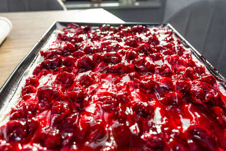 Ready Japanese cake with cottage cheese and whipped cream and fruit cherry sauce.