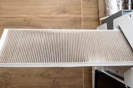Home mechanical ventilation with heat recovery hanging on the wall, visible dirty filters sticking...