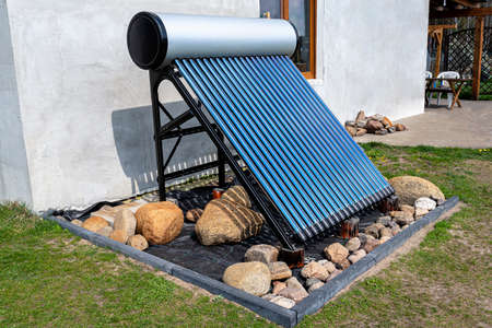 A modern solar pressure collector to heat domestic hot water, standing in front of the house on the lawn.の写真素材