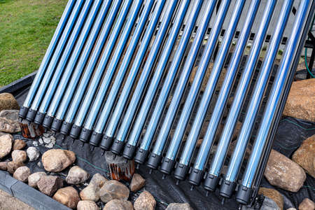 Modern pressure collector for heating domestic hot water, close-up on vacuum pipes.