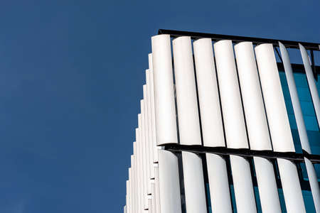 The facade of a modern building with an innovative facade made of automatic, movable blinds.