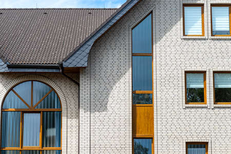 The church has a classic facade of white brick and a conical roof, visible semicircular and rectangular window.の写真素材